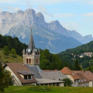 Charming village view with church and mountain backdrop in Gresse-en-Vercors, France.