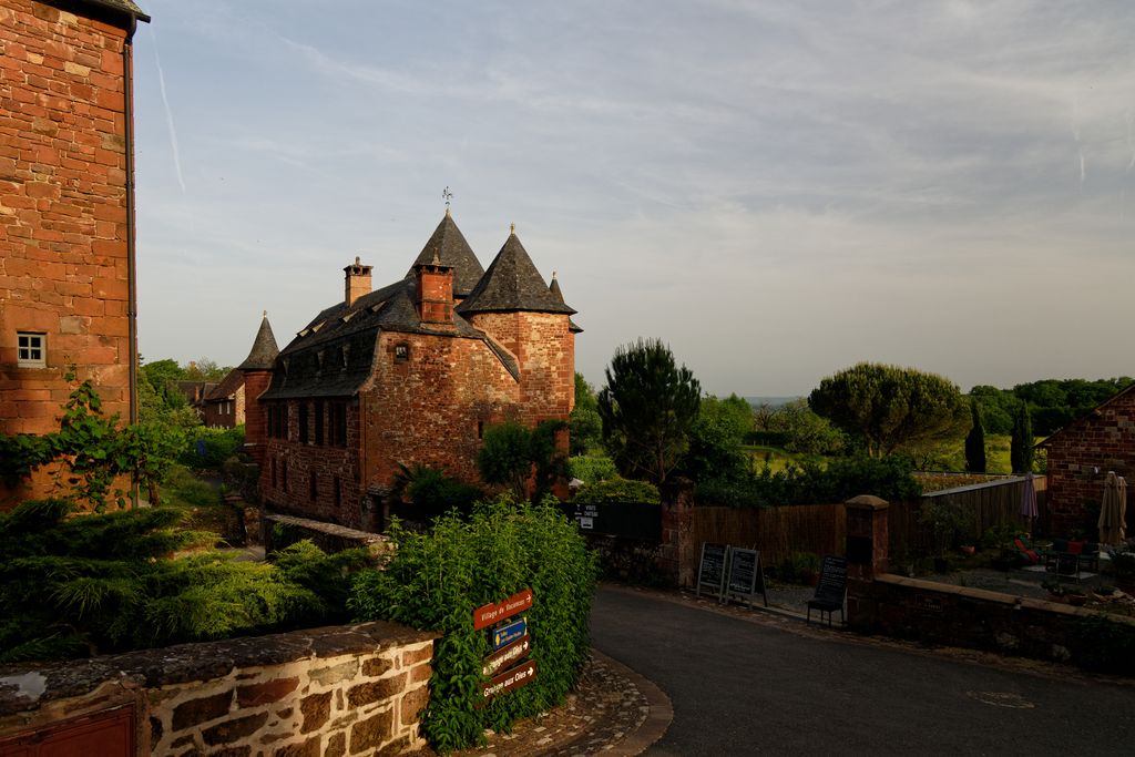 Photo par Gu Bra Explore the picturesque red-brick architecture of Collonges-la-Rouge, France, captured at sunset.