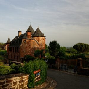 Explore the picturesque red-brick architecture of Collonges-la-Rouge, France, captured at sunset.